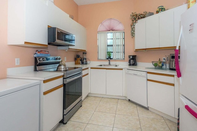 kitchen with appliances with stainless steel finishes, sink, light tile patterned floors, and white cabinets