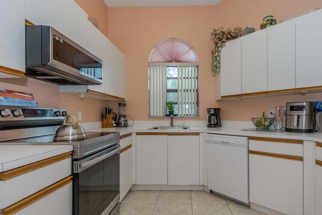 kitchen featuring light tile patterned floors, stainless steel appliances, sink, and white cabinets