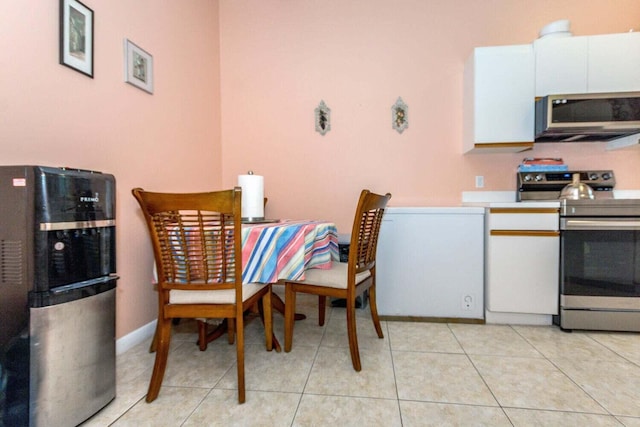 kitchen featuring light tile patterned flooring, appliances with stainless steel finishes, and white cabinets