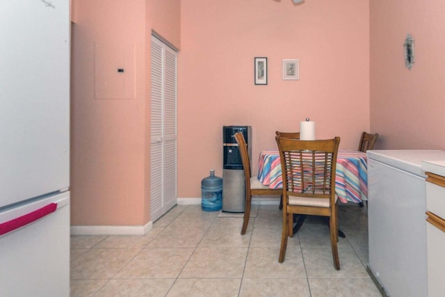 laundry area with light tile patterned floors and electric panel