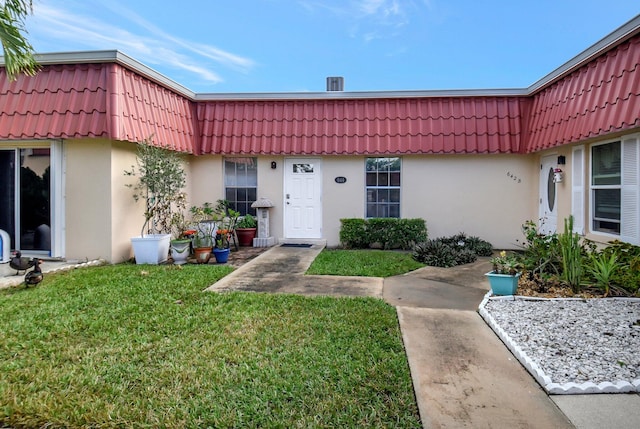 doorway to property with a lawn