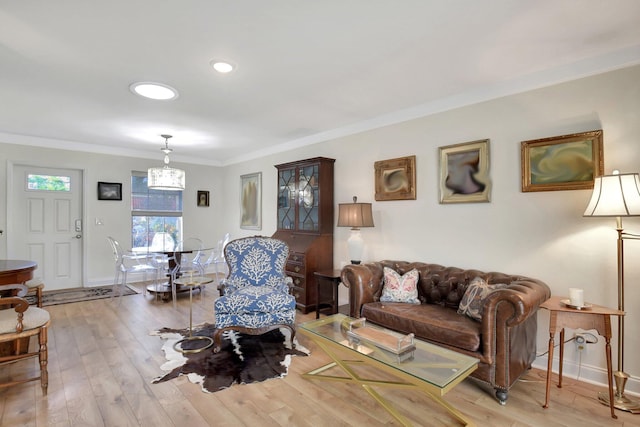 living room featuring light wood-type flooring and ornamental molding