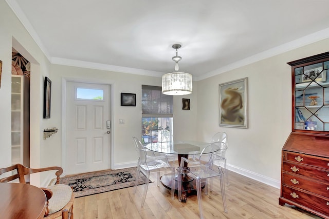 dining space with light wood-type flooring and ornamental molding