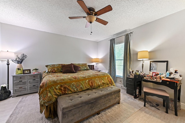 bedroom featuring ceiling fan, light hardwood / wood-style floors, and a textured ceiling