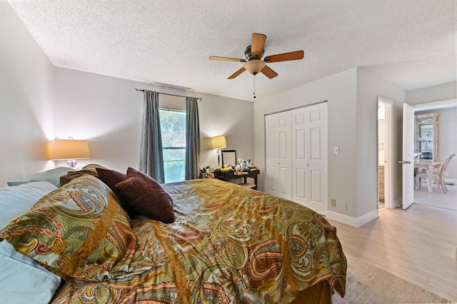 bedroom featuring ceiling fan, a closet, a textured ceiling, and light hardwood / wood-style flooring