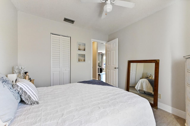 bedroom featuring hardwood / wood-style floors, a textured ceiling, a closet, and ceiling fan