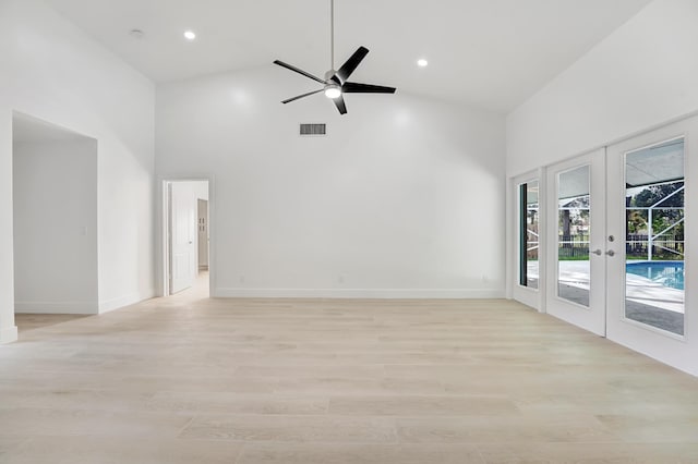 spare room featuring ceiling fan, light hardwood / wood-style floors, high vaulted ceiling, and french doors