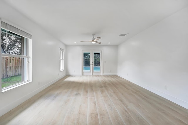 empty room featuring ceiling fan, french doors, and light hardwood / wood-style floors