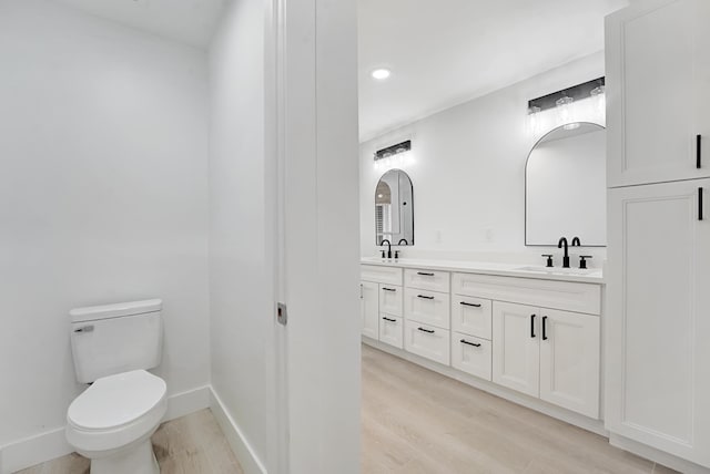 bathroom with hardwood / wood-style floors, vanity, and toilet