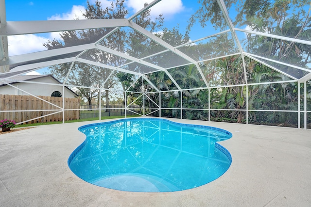 view of swimming pool featuring glass enclosure and a patio area