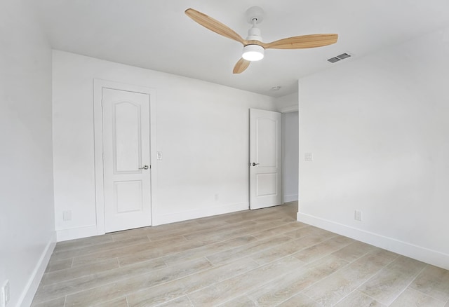 spare room with ceiling fan and light wood-type flooring