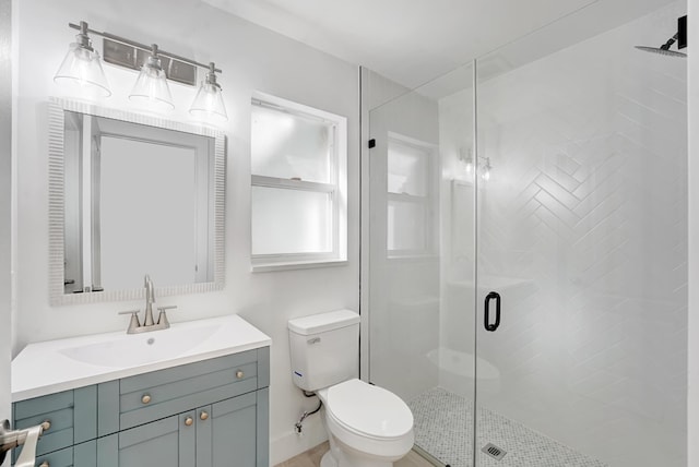 bathroom with a shower with door, vanity, and toilet