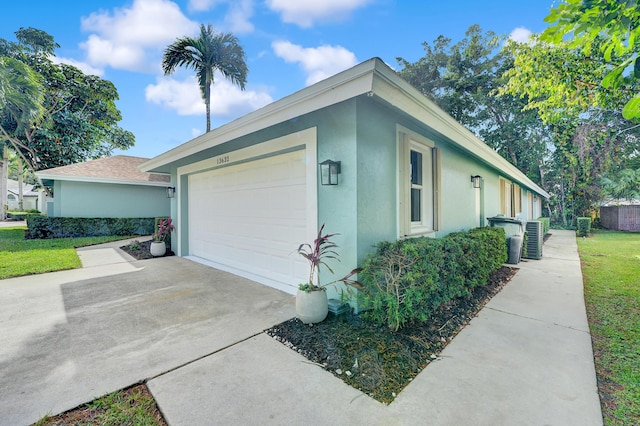 view of side of home featuring central AC and a garage