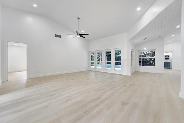 unfurnished living room featuring ceiling fan, light hardwood / wood-style floors, high vaulted ceiling, and french doors