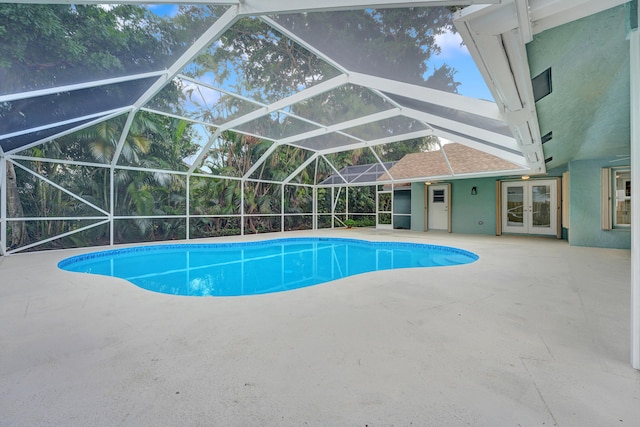 view of swimming pool with french doors, a patio, and a lanai