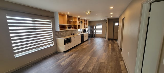 kitchen featuring dark hardwood / wood-style flooring, dishwasher, sink, and backsplash