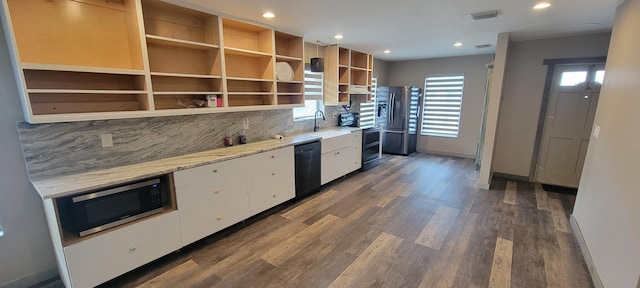 kitchen with appliances with stainless steel finishes, tasteful backsplash, white cabinetry, sink, and dark wood-type flooring