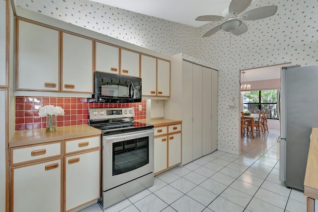 kitchen featuring ceiling fan with notable chandelier, light tile patterned flooring, appliances with stainless steel finishes, and tasteful backsplash