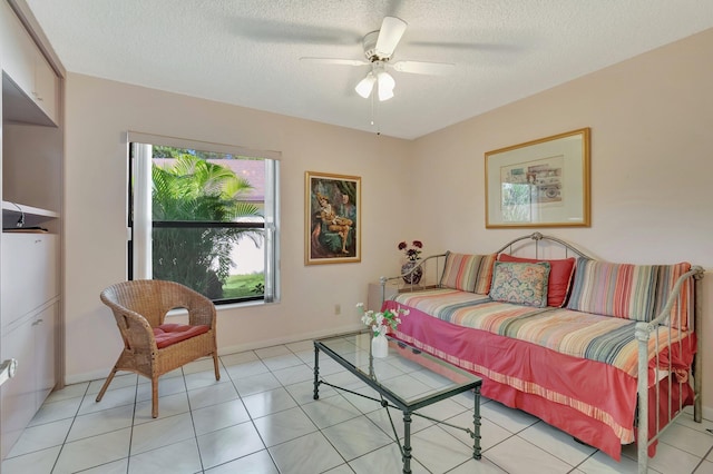 tiled living room with ceiling fan, a healthy amount of sunlight, and a textured ceiling