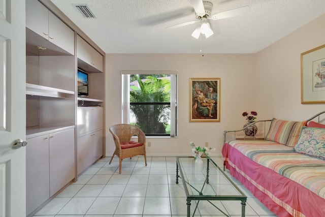 tiled living room featuring ceiling fan and a textured ceiling