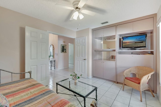 tiled living room featuring ceiling fan and a textured ceiling