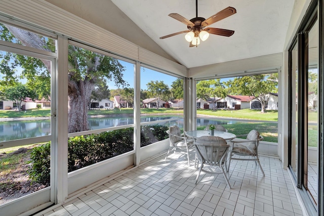 sunroom with ceiling fan, a healthy amount of sunlight, a water view, and lofted ceiling