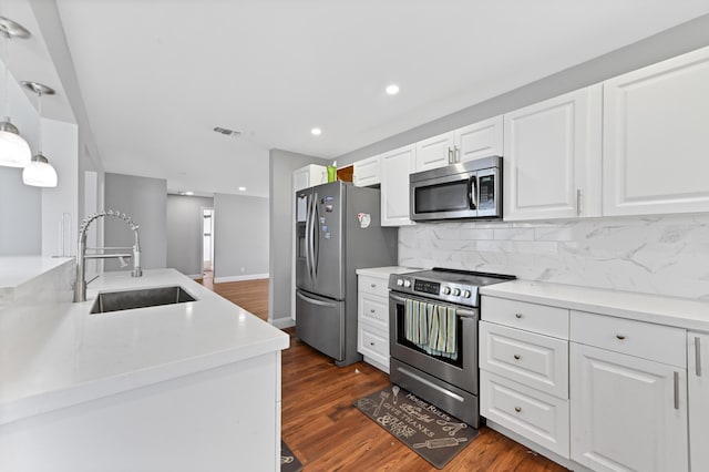 kitchen featuring dark hardwood / wood-style floors, white cabinetry, sink, and appliances with stainless steel finishes