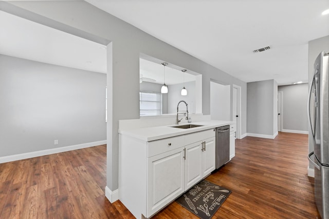 kitchen featuring dark hardwood / wood-style floors, white cabinets, stainless steel appliances, and decorative light fixtures