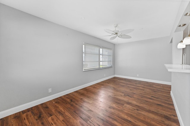 empty room with dark hardwood / wood-style floors and ceiling fan