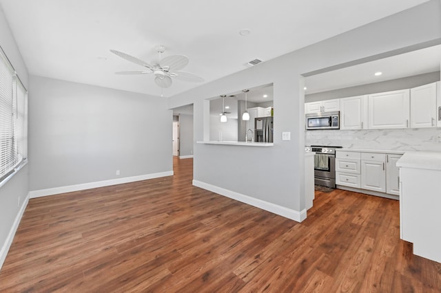 kitchen with backsplash, dark wood-type flooring, white cabinets, ceiling fan, and appliances with stainless steel finishes