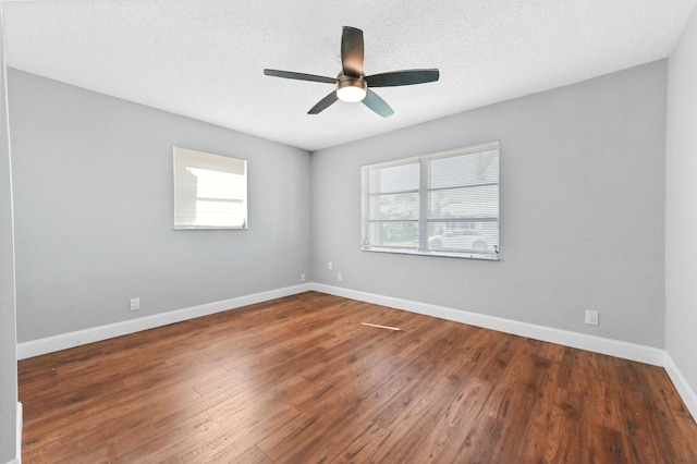 spare room with a textured ceiling, dark hardwood / wood-style flooring, and ceiling fan