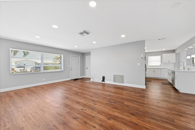 unfurnished living room with wood-type flooring and sink