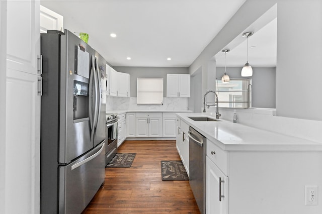 kitchen featuring white cabinetry, sink, dark wood-type flooring, decorative backsplash, and appliances with stainless steel finishes