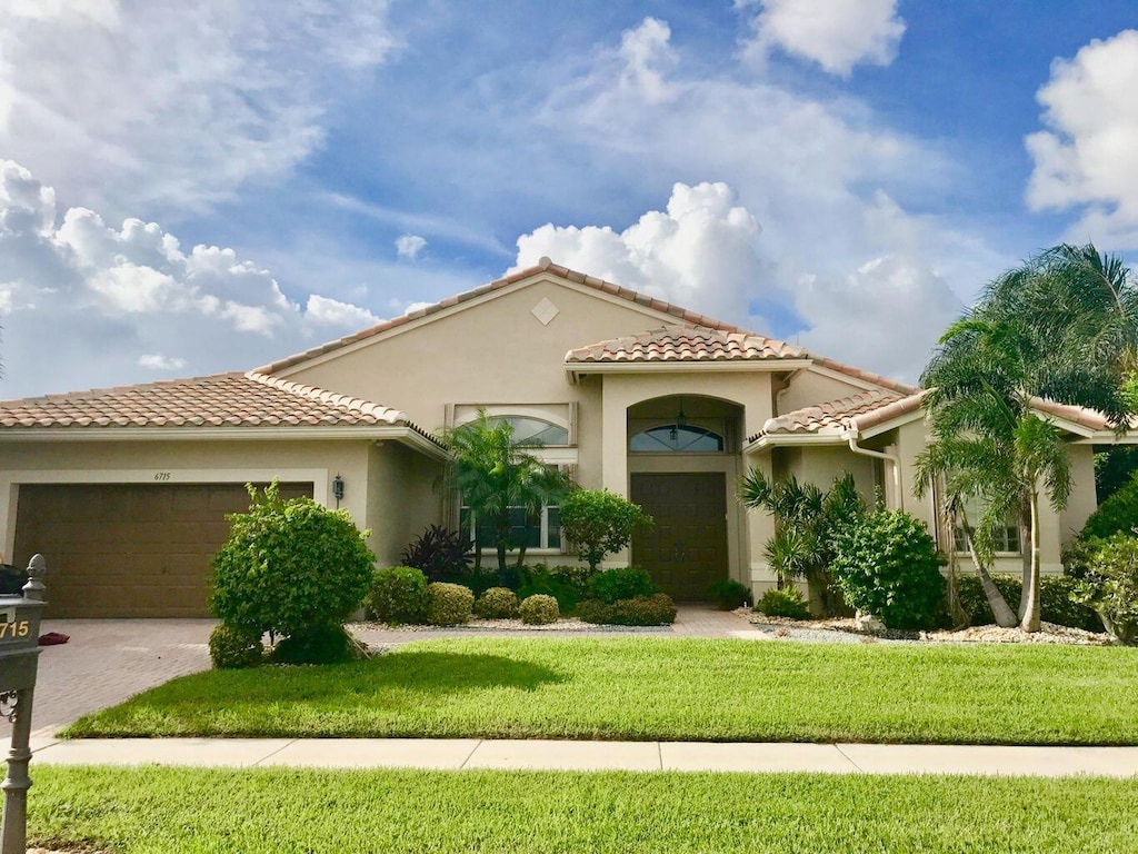 mediterranean / spanish-style home with a garage and a front yard