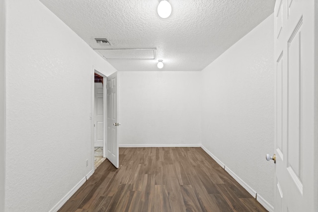 interior space featuring a textured ceiling and dark wood-type flooring