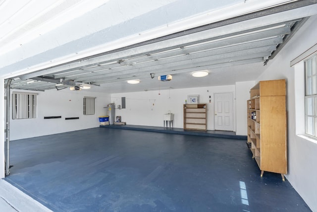 garage featuring electric water heater, electric panel, a garage door opener, and sink