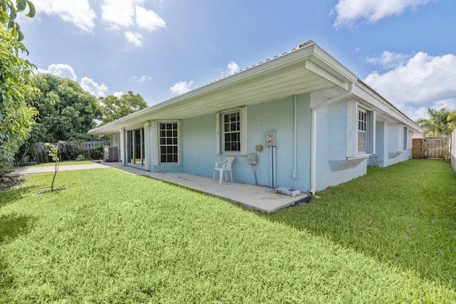 back of house featuring a yard and central AC unit