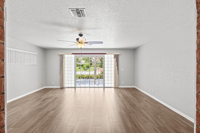 spare room featuring dark hardwood / wood-style floors, ceiling fan, and a textured ceiling