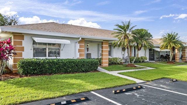 single story home featuring a front lawn