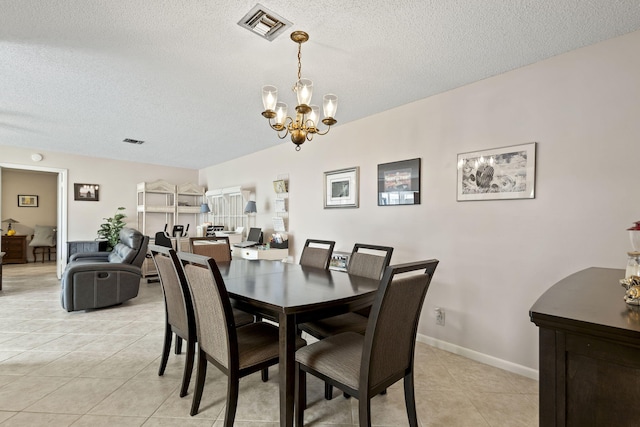 tiled dining space featuring a notable chandelier and a textured ceiling