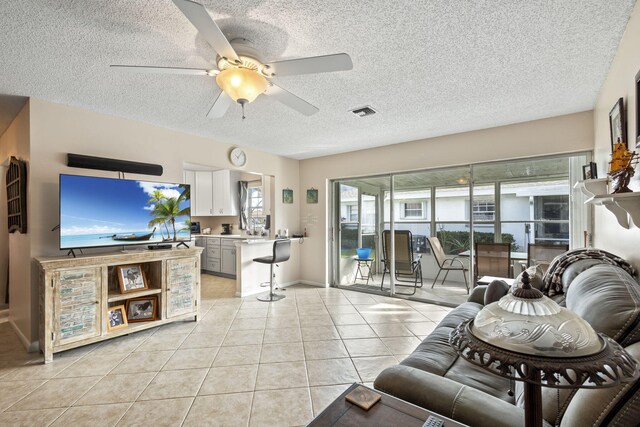 living room featuring light tile patterned flooring, a healthy amount of sunlight, and a textured ceiling