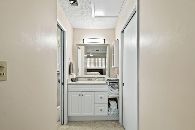 bathroom with a textured ceiling, vanity, and tile patterned floors