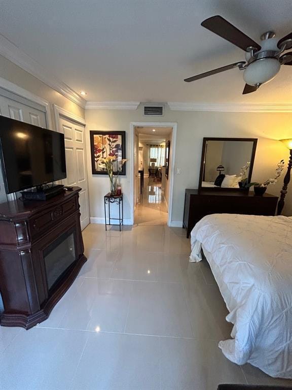 tiled bedroom featuring ceiling fan, crown molding, and a closet