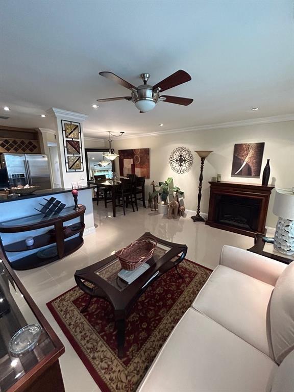 living room with crown molding and ceiling fan