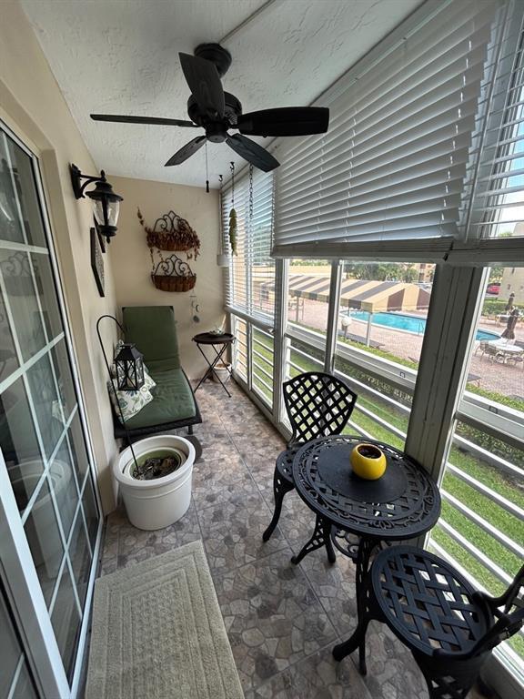 sunroom / solarium featuring ceiling fan