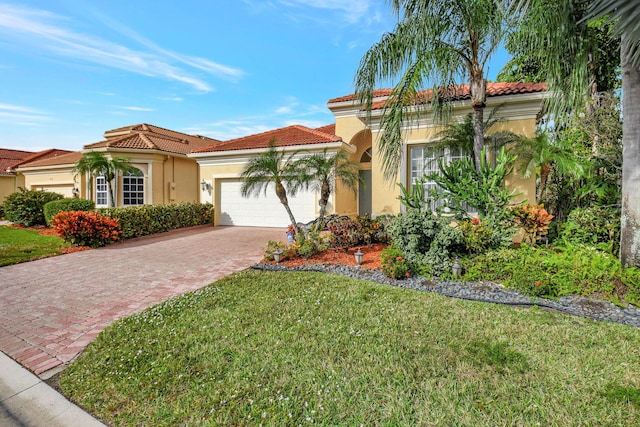 mediterranean / spanish house featuring a garage and a front lawn