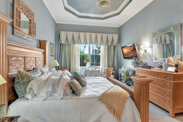 bedroom with a raised ceiling and light colored carpet