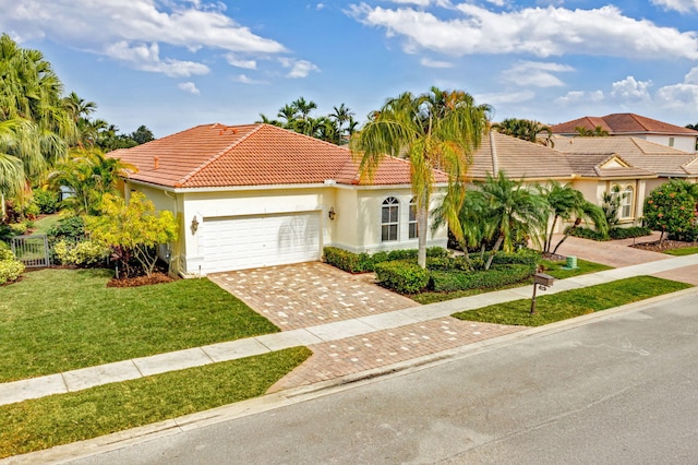 mediterranean / spanish home with a front yard and a garage