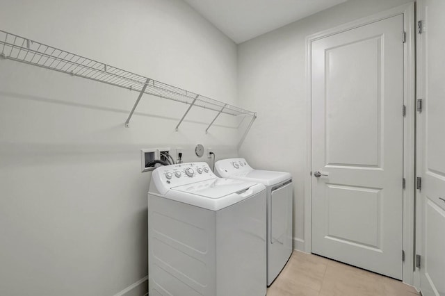 laundry area with separate washer and dryer and light tile patterned flooring