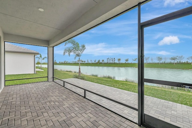 unfurnished sunroom featuring a water view